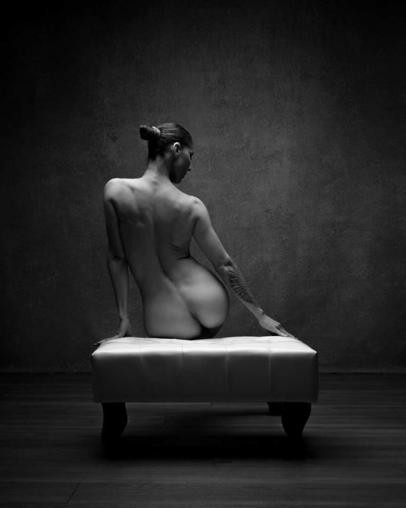 Woman seated from behind, spine and shoulder exposed