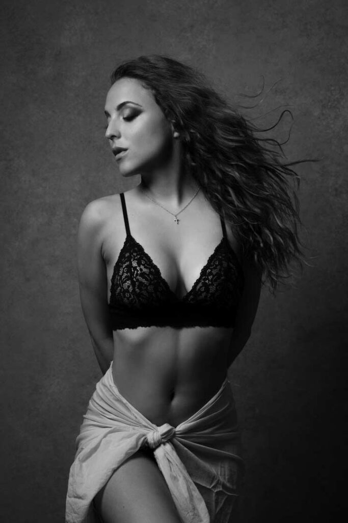 Elegant woman in black lace lingerie, captured in a timeless studio portrait