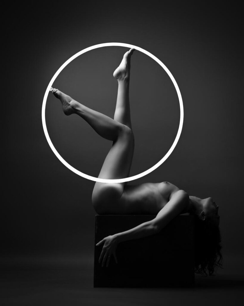 Nude woman in graceful pose with circular frame
